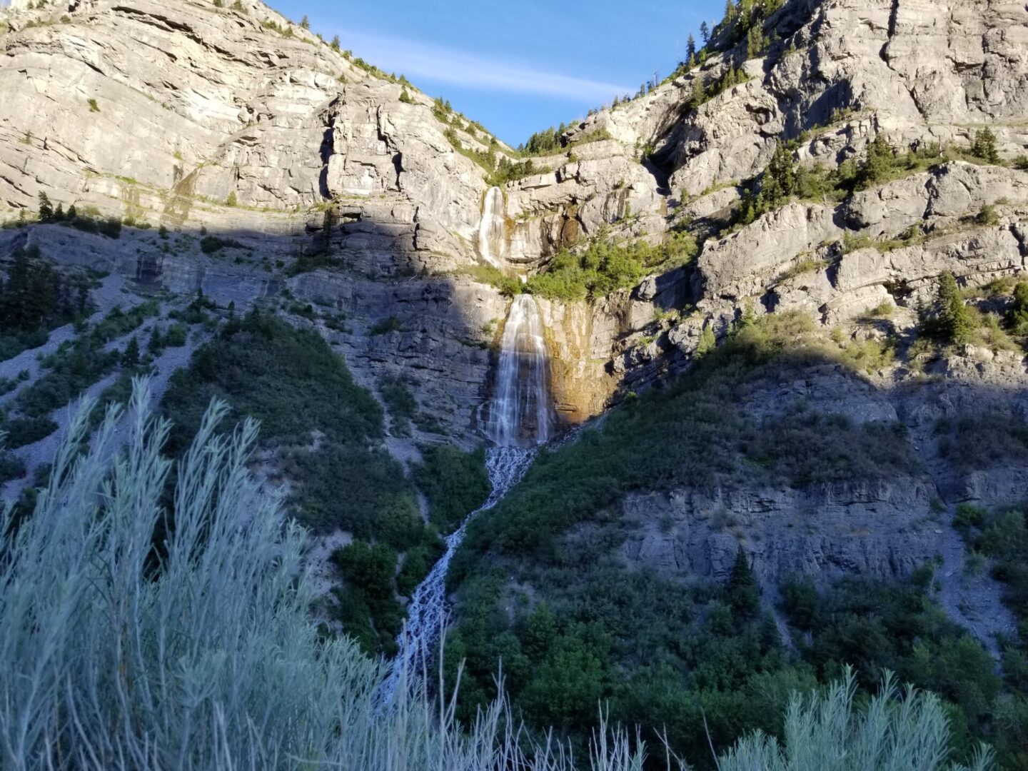 Mountain waterfall on a rock at sunset.