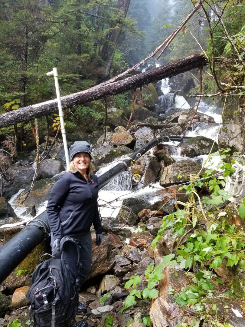 A women posing for a photo behind the waterfalls