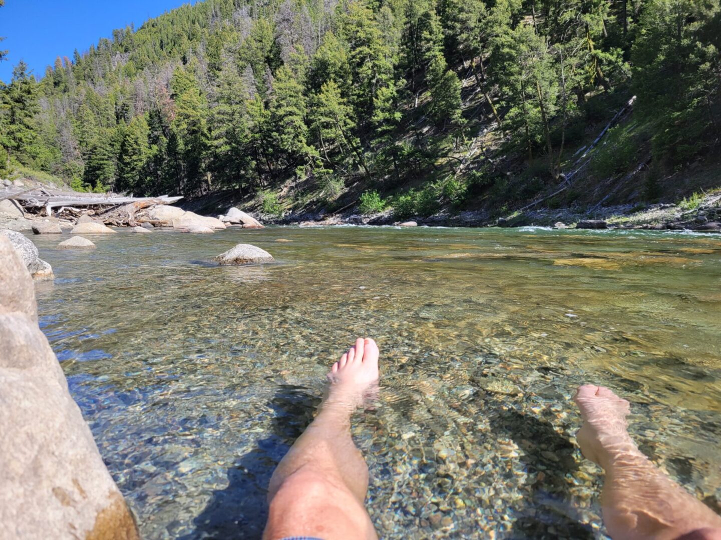 Man with his feet on a mountain river